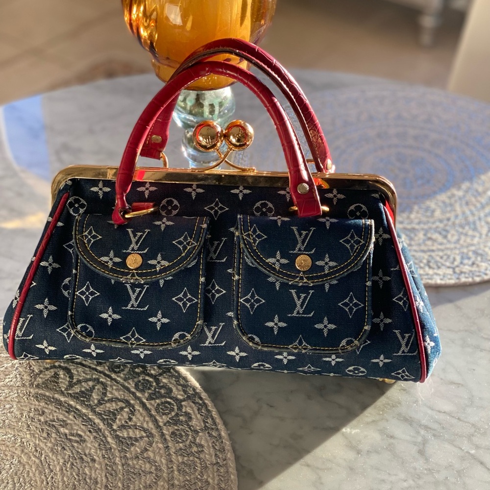 Denim handbag with dark red accents.